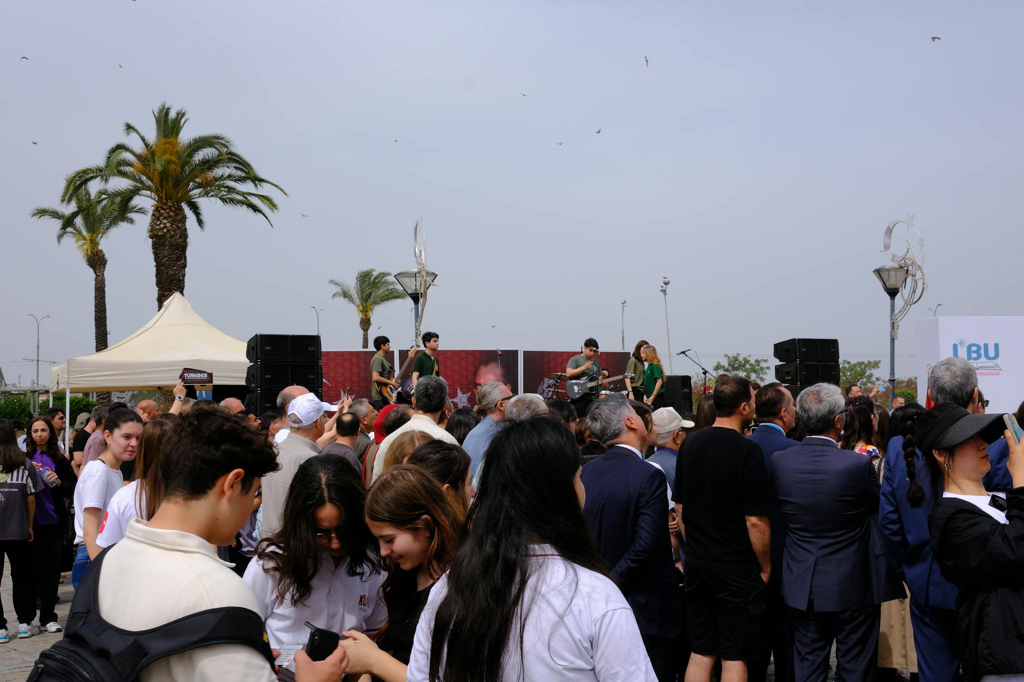 Vibrant crowd enjoying a live music performance at an outdoor event in Izmir, Türkiye.